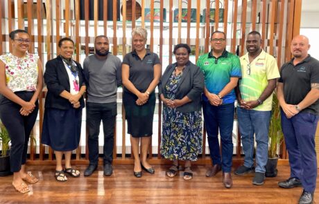 A diverse group stands before a wooden wall, facilitating discussions on regional knowledge sharing in the yachting sector.